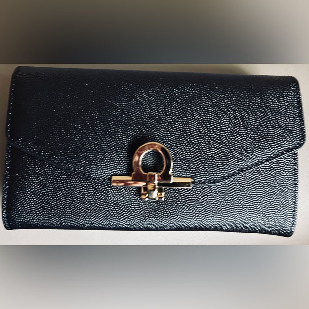 Black Caviar Italian leather clutch with flip-lock and drop-in chain. NWT